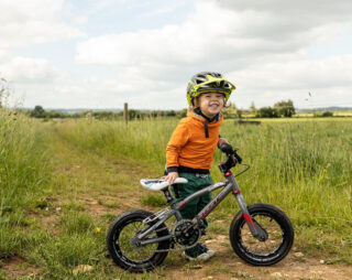 Young boy smiling in yellow Troy Lee Designs helmet on kids mountain bike