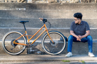 Man sitting on stairs, next to a Marin Larkspur 2 bike.