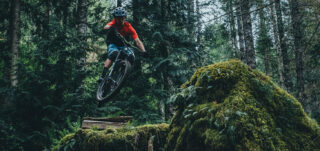 Mark Matthews launching off a ramp, deep in the woods of British Columbia.