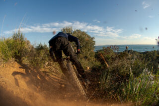 Marin's Matt Cipes, kicking up gravel, riding a mountain bike in Italy.