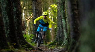 Nikki Whiles riding a Rift Zone Carbon 2 mountain bike through the trees, Wales UK.