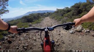 Point-of-view shot of rider on a Marin Alpine Trail E1 bike, climbing a rough fire road.